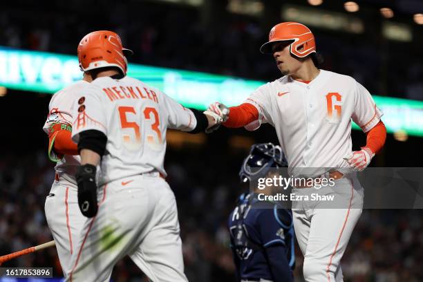 Wilmer Flores of the San Francisco Giants is congratulated Wade Meckler after he hit a two-run home run against the Tampa Bay Rays in the sixth...