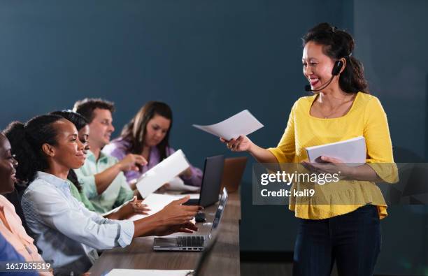 filipina instructor in class, handing out papers - microphone test stock pictures, royalty-free photos & images