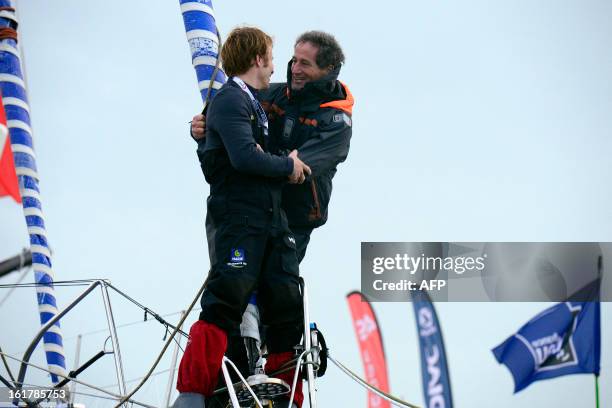 French skipper Francois Gabart celebrates on his boat with French navigator Michel Desjoyeaux after winning the 7th edition of the Vendee Globe solo...