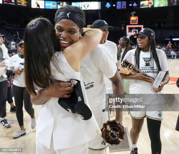 Head coach Sandy Brondello of the New York Liberty hugs Jonquel Jones after she won the MVP trophy as Jocelyn Willoughby carries the championship...