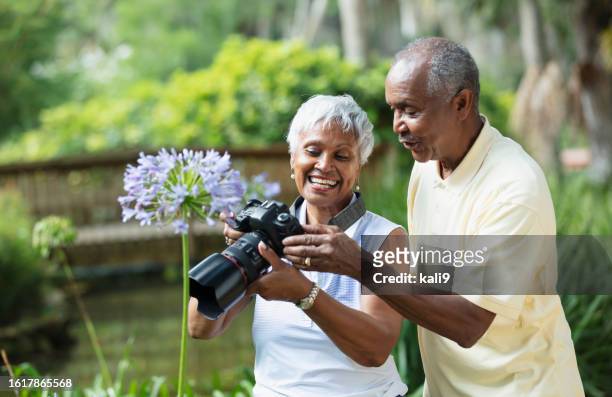 pareja afroamericana mayor tomando fotos en el parque - lili gentle fotografías e imágenes de stock