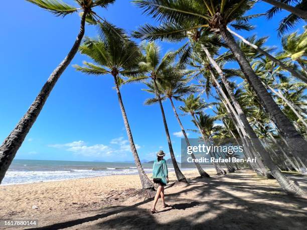 australian woman walking on a footpath in palm cove queensland australia - cairns australië stockfoto's en -beelden