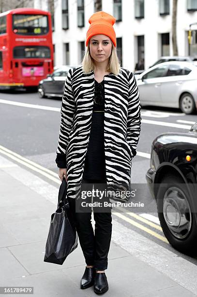 Blogger Lian poses wearing a Zara coat, New Yorker trousers, sunglasses and shoes from Topshop with a bag by Marc by Marc Jacobs and a beanie hat...