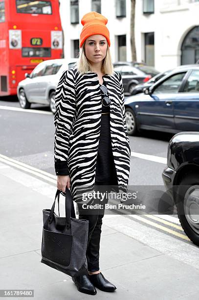 Blogger Lian poses wearing a Zara coat, New Yorker trousers, sunglasses and shoes from Topshop with a bag by Marc by Marc Jacobs and a beanie hat...