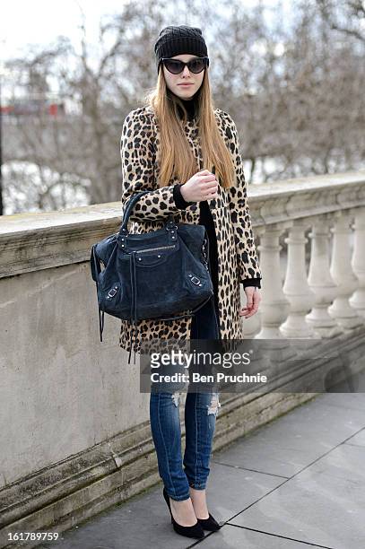 Blogger Anna poses wearing a Uniglo hat, Bruno Maneti top, Zara coat and jeans with Cassidy shoes and a Balenciaga bag at Somerset House during...