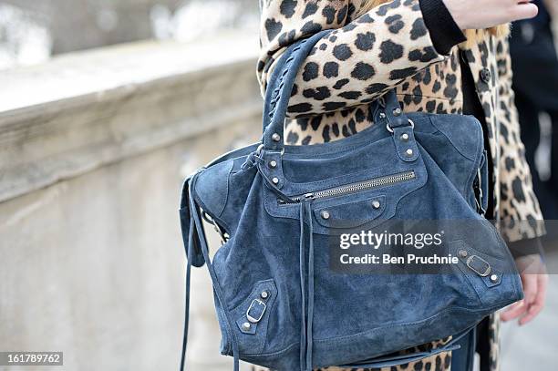 Blogger Anna poses wearing a Uniglo hat, Bruno Maneti top, Zara coat and jeans with Cassidy shoes and a Balenciaga bag at Somerset House during...