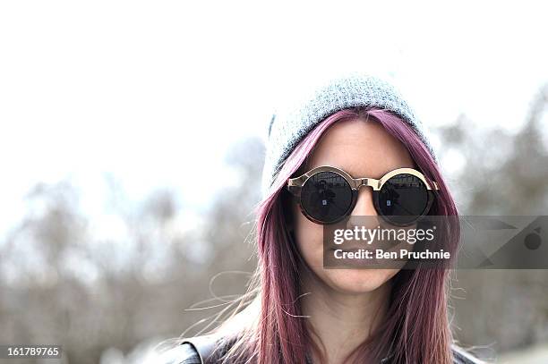 Student Kelly poses wearing an express jacket with top shop crop top, shorts and shoes with a next beanie at Somerset House during London Fashion...