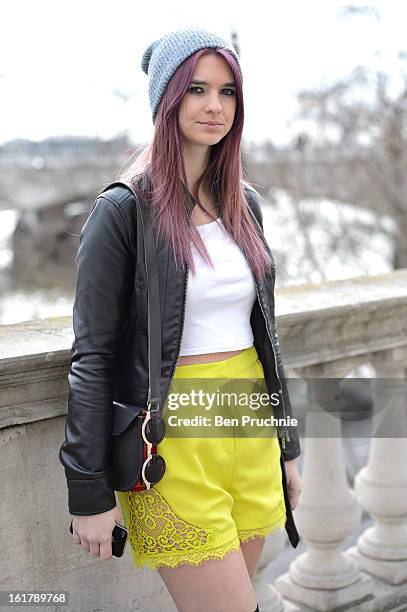 Student Kelly poses wearing an express jacket with top shop crop top, shorts and shoes with a next beanie at Somerset House during London Fashion...