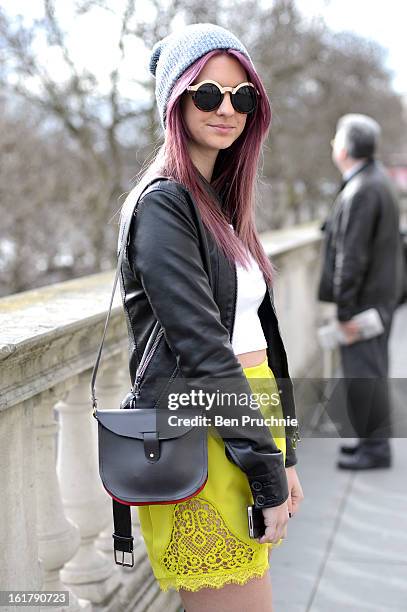 Student Kelly poses wearing an express jacket with top shop crop top, shorts and shoes with a next beanie at Somerset House during London Fashion...