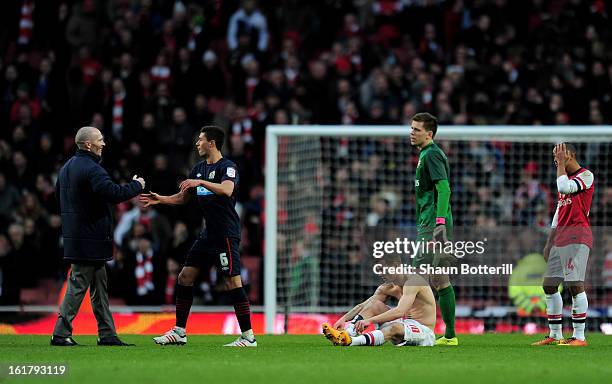 Dejected Arsenal players look on as Michael Appleton the Blackburn manager and Jason Lowe of Blackburn celebrate their team's 1-0 victory during the...