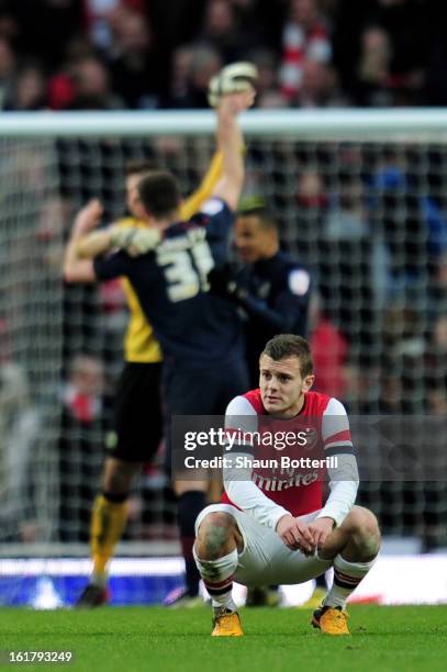 Dejected Arsenal player Jack Wilshere looks on as Blackburn players celebrate their team's 1-0 victory during the FA Cup with Budweiser fifth round...