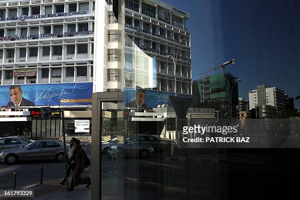 Poster of Cyprus candidate for presidential elections George Lillikas decorates a building in Nicosia central business district as its reflection is...