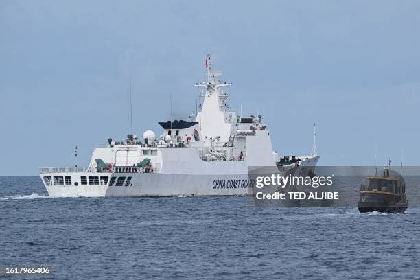 This photo taken on August 22, 2023 shows a Chinese coast guard ship shadowing a Philippine civilian boat chartered by the Philippine navy to deliver...