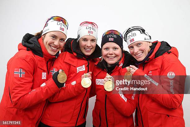In this handout image provided by IBU, Synnoeve Solemdal, Ann Kristin Aafedt Flatland, Hilde Fenne and Tora Berger of Norway pose with their medals...