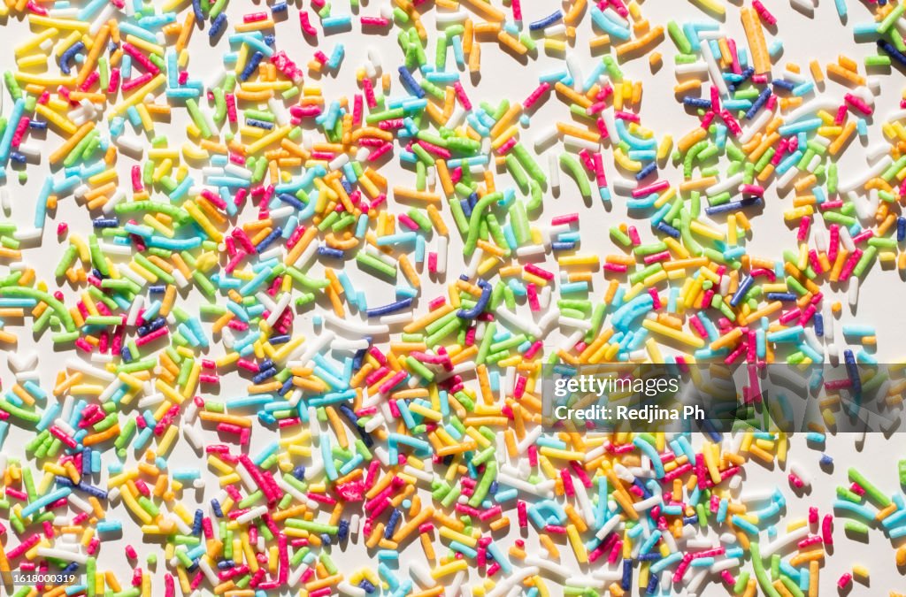 Vibrant photo showcasing a multicolored pattern of bright sprinkles for doughnuts and Easter baking.