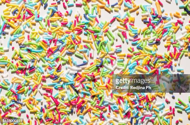 vibrant photo showcasing a multicolored pattern of bright sprinkles for doughnuts and easter baking. - blue donut white background stock pictures, royalty-free photos & images