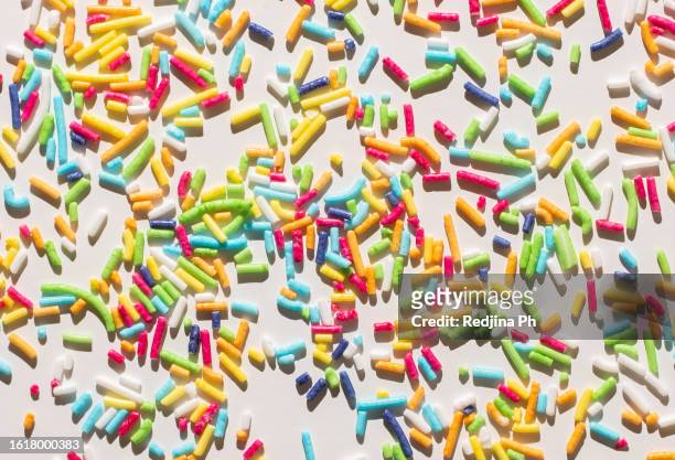 vibrant photo showcasing a multicolored pattern of bright sprinkles for doughnuts and easter baking. - gekleurde hagelslag stockfoto's en -beelden
