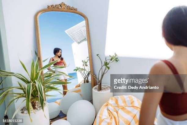 young asian woman posing in front of large mirror - large mirror stock pictures, royalty-free photos & images