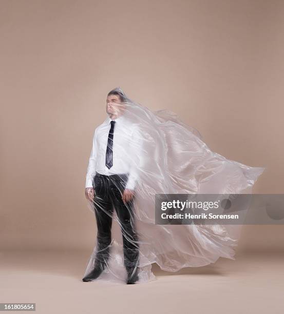 businessman wrapped in plastic - man wrapped in plastic stock pictures, royalty-free photos & images