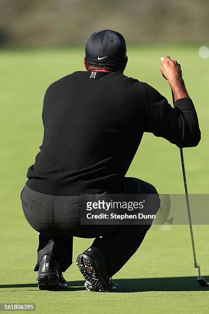 Tiger Woods lines up a putt on the 13th hole during the final round of the Farmers Insurance Open on the South Course at Torrey Pines Golf Course on...