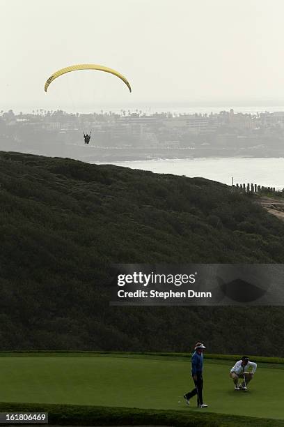 Paraglider flies near the third green during the final round of the Farmers Insurance Open on the South Course at Torrey Pines Golf Course on January...