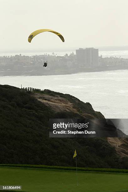 Paraglider flies near the third green during the final round of the Farmers Insurance Open on the South Course at Torrey Pines Golf Course on January...
