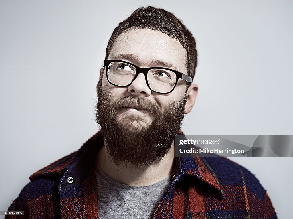 Man with beard and glasses looking up to side