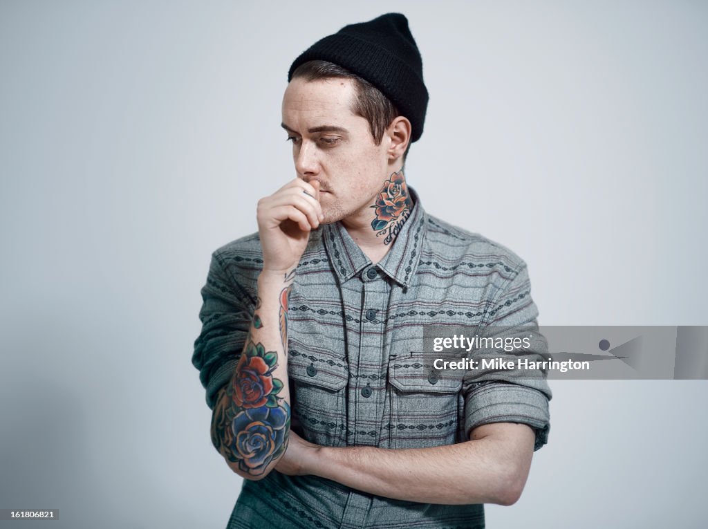 Man wearing woolly hat looking down to side.