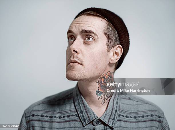man with tattooed neck and woollen hat looking up. - name tattoos stock pictures, royalty-free photos & images