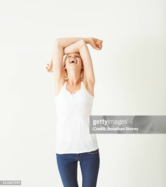 female tilting head back with arms over her head - vest stock pictures, royalty-free photos & images