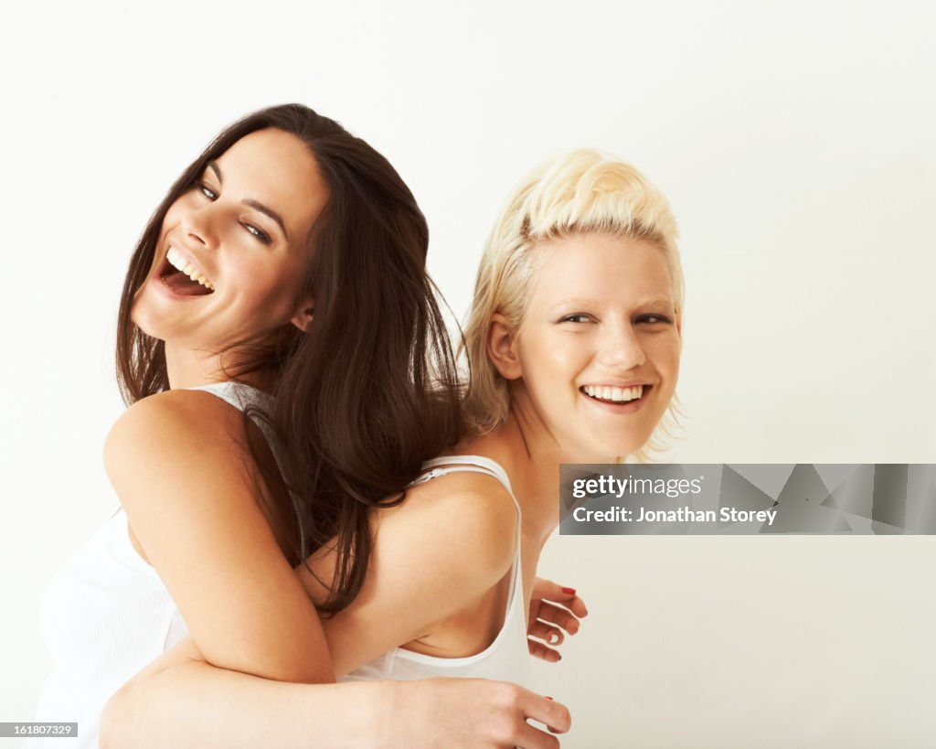 Blond and brunette leaning on eachother