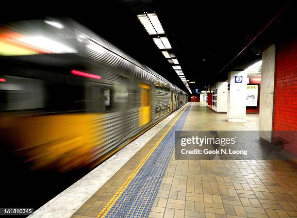 Speeding fast train with motion blur leaving at Town Hall Railway Station, Sydney. Image of an empty underground railway station with lighting,...