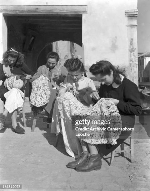 Women sit in the courtyard making lace, Burano, Venice, 1949.