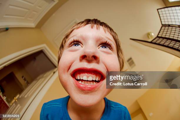 little boy laughing while hovering over camera - fischaugen objektiv stock-fotos und bilder