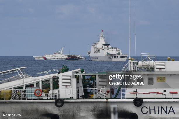 This photo taken on August 22, 2023 shows Chinese coast guard ships corralling one of the civilian boats chartered by the Philippine navy to deliver...