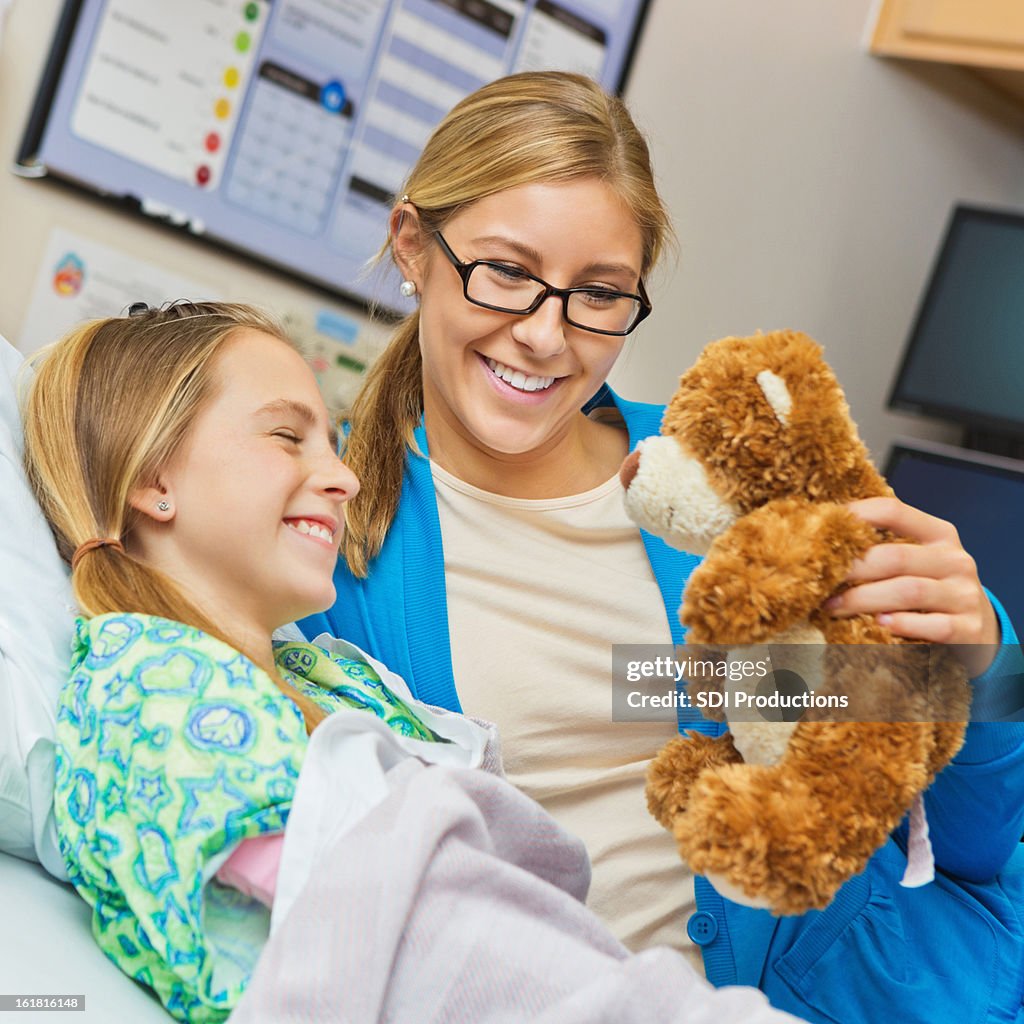 Mother cheering up sick daughter in hospital