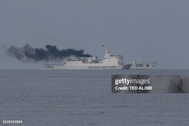 This photo taken on August 22, 2023 shows a Chinese coast guard ship shadowing Philippine coast guard ships during the re-supply mission by a...