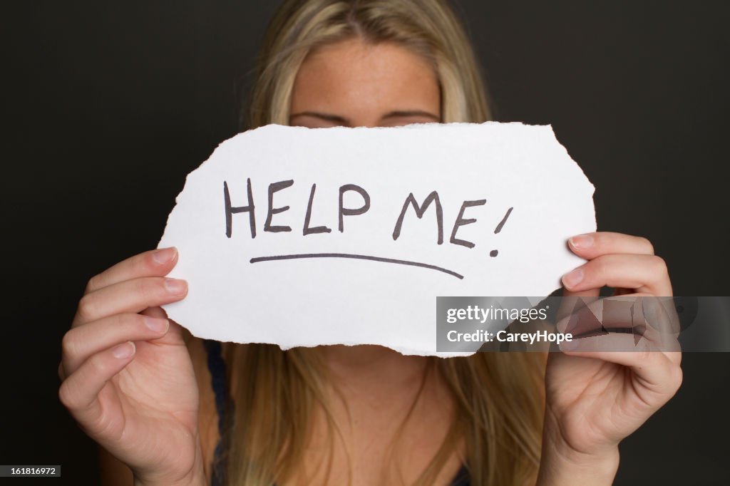 Girl holding help me sign