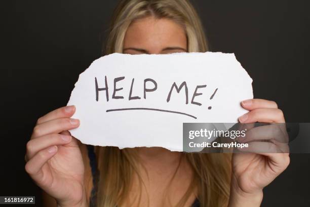 girl holding help me sign - victim advocacy stock pictures, royalty-free photos & images