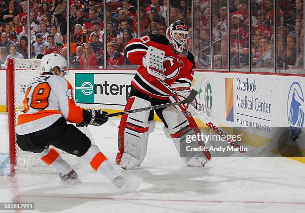 Martin Brodeur of the New Jersey Devils plays the puck away from Danny Briere of the Philadelphia Flyers at the Prudential Center on February 15,...