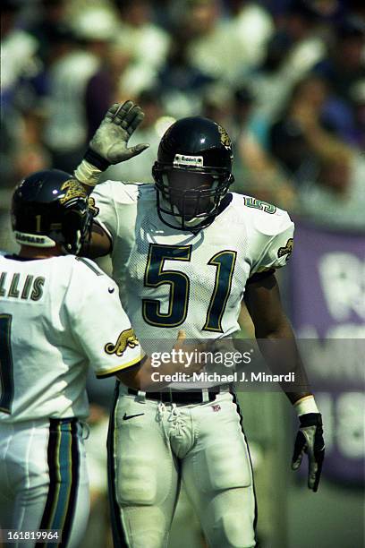 Linebacker Kevin Hardy of the Jacksonville Jaguars congradulates Mike Hollis the kicker for a good punt during an NFL game against the Baltimore...