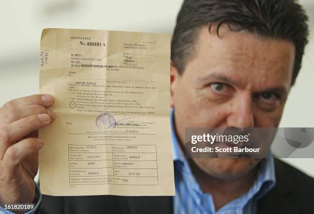 South Australian Federal Senator Nick Xenophon holds up his deportation notice as he arrives at Adelaide Airport after his deportation from Malaysia,...