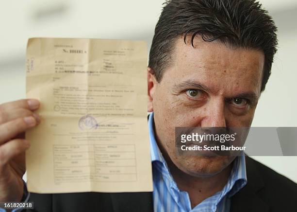 South Australian Federal Senator Nick Xenophon holds up his deportation notice as he arrives at Adelaide Airport after his deportation from Malaysia,...