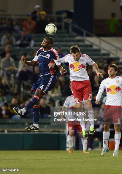 Kalifa Cisse of New England Revolution heads the ball against defender Andrew Ribeiro of the New York Red Bulls in the first half during the FC...