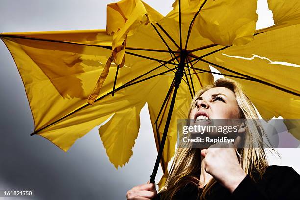 not singing in the rain: frustrated woman with broken umbrella - yellow umbrella stock pictures, royalty-free photos & images