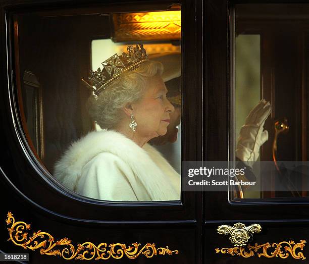 Britain's Queen Elizabeth II rides in the Golden State Carriage down Whitehall to deliver her annual speech to MPs in the House of Lords November 13,...