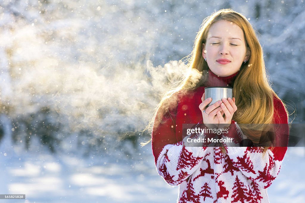 Schönes Mädchen trinkt heißes Getränk für winter