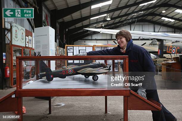 An employee at the Lincolnshire Aviation Heritage Centre cleans a display case in the hangar of the Lancaster bomber "Just Jane", which is being...