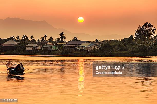puesta de sol sobre el río en kuching, borneo - borneo fotografías e imágenes de stock