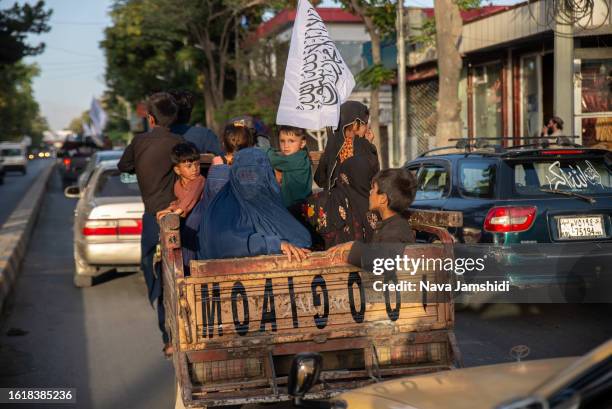 Woman and children ride in a truck during a parade of Taliban supporters on August 15, 2023 in Kabul, Afghanistan. Two years ago, the Taliban...